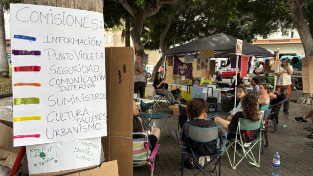 Die Teilnehmer des Wohnrechts-Camps in Las Palmas de Gran Canaria verfolgen die Debatte im Kongress über die beiden von der Regierung verabschiedeten
